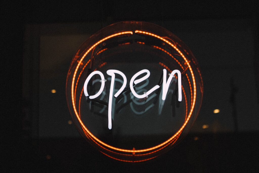 A circular neon sign that reads "open".
